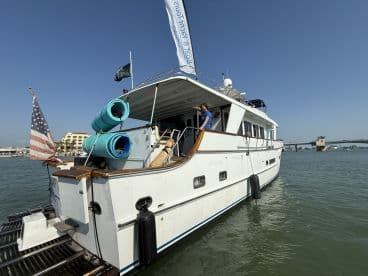 A stunning yacht docked with a clear view of its exterior, showcasing the American flag and vibrant blue accessories, perfect for luxury boating experiences.