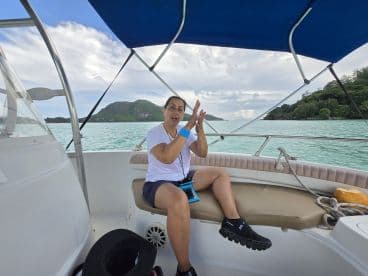 A joyful moment aboard a boat as a woman expresses excitement, surrounded by beautiful scenery — perfect for capturing fun experiences on the water.