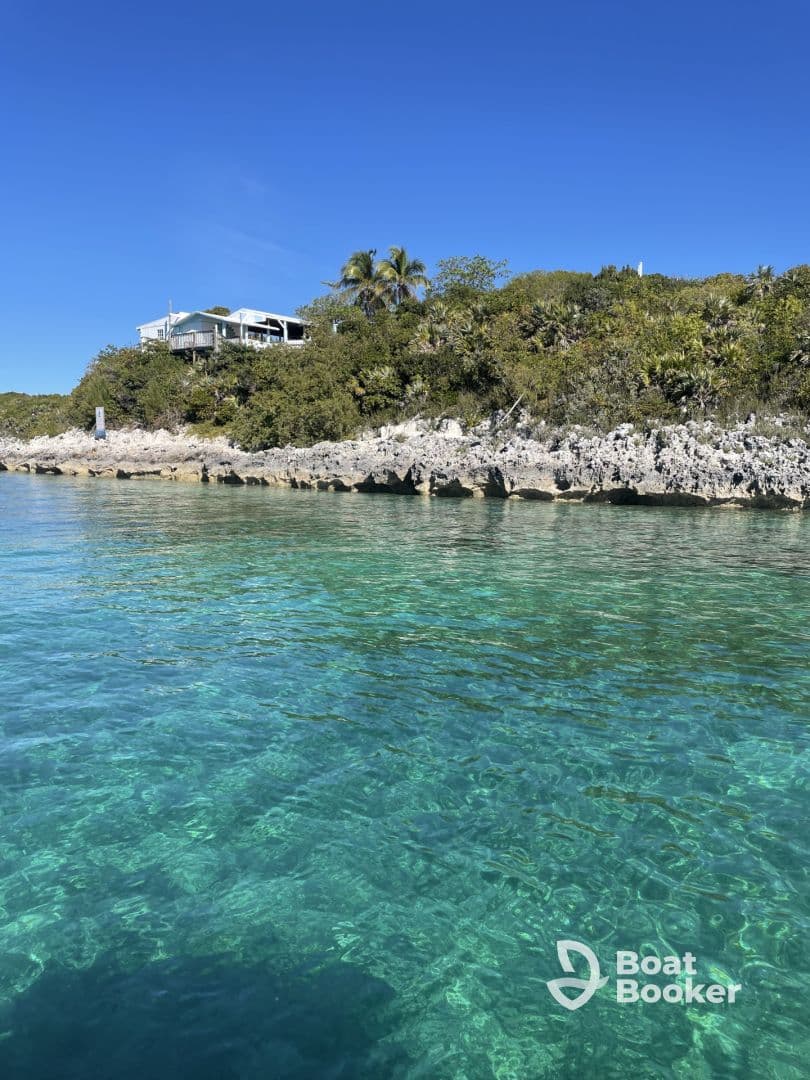 A picturesque view of a serene coastline with clear turquoise waters and lush greenery, perfect for showcasing the beauty of island destinations.