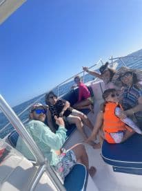 A cheerful group of family and friends enjoys a sunny day on the boat, showcasing the joy of ocean adventures together.