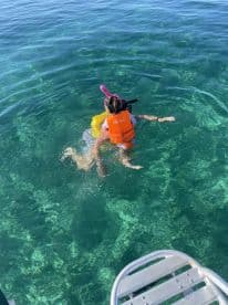 Two children enjoy snorkeling in crystal-clear waters, showcasing a fun and adventurous day on the water.