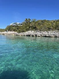 A picturesque view of a serene coastline with clear turquoise waters and lush greenery, perfect for showcasing the beauty of island destinations.