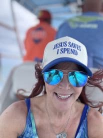 A joyful woman takes a selfie on a boat, showcasing her vibrant personality and fun spirit while enjoying a day on the water.