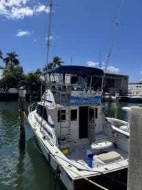 A well-maintained yacht docked at the marina, showcasing its sleek design and spacious back deck, perfect for fishing or leisure outings.