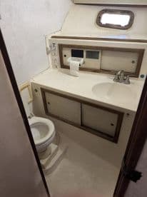 Interior view of a boat bathroom featuring a toilet and sink, showcasing the essential amenities for comfort on the water.