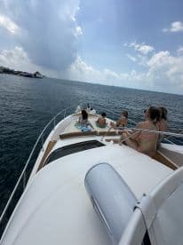 A group enjoys a sunny day on a boat, soaking up the sun and taking in the ocean views — perfect for a fun day out on the water.