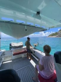Inside view of a boat's cabin featuring two guests, one preparing food while the other enjoys the serene surroundings — perfect for relaxing outings on the water.