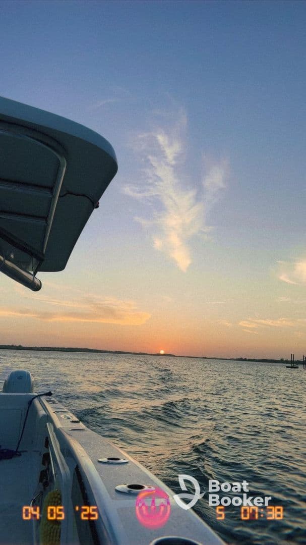 A serene sunset view from the side of a boat, capturing the tranquil waters and vibrant sky, perfect for evening cruises.