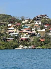 A scenic view of hillside homes overlooking the water, showcasing the beauty of coastal living.