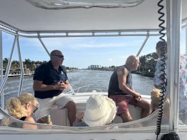A group of friends enjoys a scenic boat ride, engaging in conversation and taking in the beautiful waterfront views.