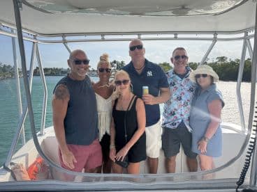 A cheerful group of friends poses for a photo aboard a boat, capturing the essence of fun and camaraderie on the water.