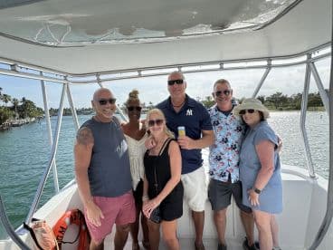 A cheerful group of friends enjoys a sunny day on the boat, capturing the essence of fun and camaraderie on the water.