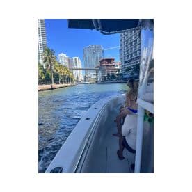 A scenic view from a boat navigating through a vibrant city waterway, showcasing the blend of urban architecture and leisure on the water.
