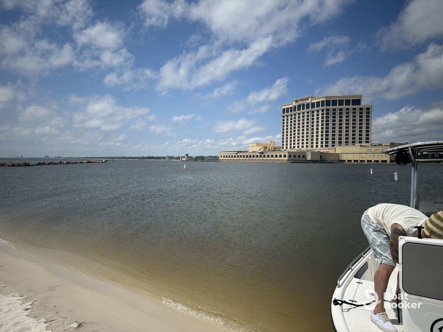 A scenic view featuring a boat and a hotel in the background, with a person preparing on the boat — perfect for capturing moments of relaxation and adventure on the water.
