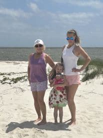 A joyful family poses together on the beach, capturing a memorable moment in the sun — perfect for family vacations and beach outings.