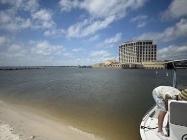 A scenic view featuring a boat and a hotel in the background, with a person preparing on the boat — perfect for capturing moments of relaxation and adventure on the water.