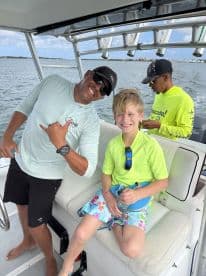 A joyful moment aboard a boat with a smiling adult and a child, showcasing the fun and excitement of a family outing on the water.