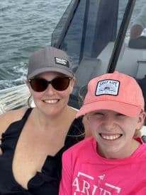 A joyful moment captured of a mother and daughter enjoying their time on a boat, showcasing the fun and connection of family outings on the water.