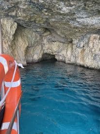A view of a cave entrance with turquoise water, showcasing the natural beauty of the surroundings. The image lacks clarity and focus.