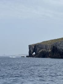 A stunning view of a coastal landmark featuring a natural rock arch, perfect for scenic boat tours and exploration.