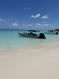A sleek speedboat anchored on a pristine beach, surrounded by crystal-clear turquoise waters — an ideal spot for relaxation and water adventures.