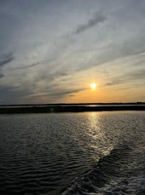 A serene sunset view over calm waters, showcasing the beauty of nature during a boat ride — perfect for tranquil evening cruises.