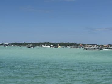 A scenic view of multiple boats anchored in clear turquoise waters, showcasing a vibrant boating atmosphere perfect for summer outings.