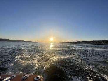 A stunning sunset view over the water, captured from a boat, showcasing the serene beauty of the evening sky and gentle waves.