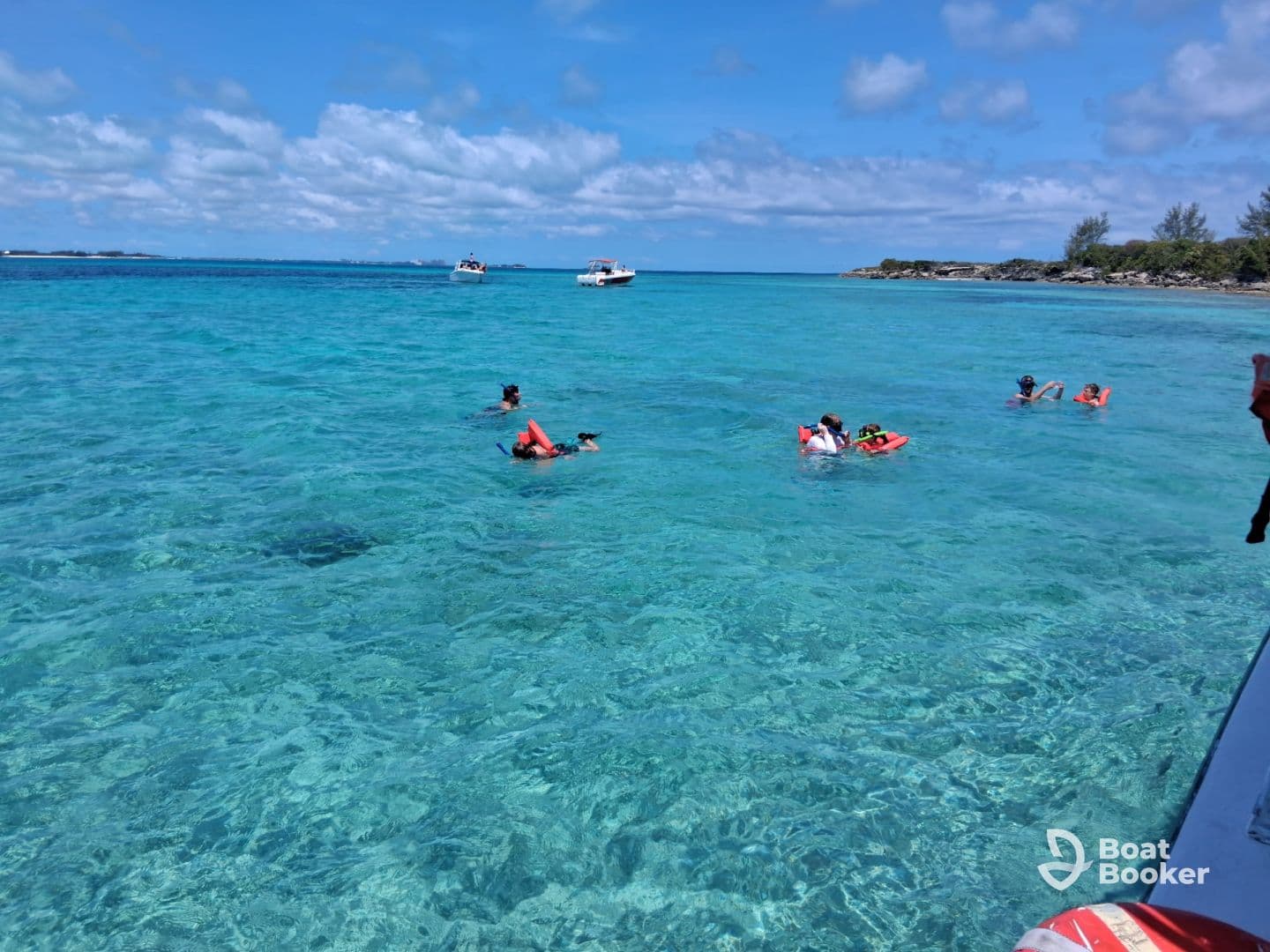 A lively group enjoys snorkeling in the crystal-clear waters, showcasing the beauty of marine life and the excitement of underwater exploration.