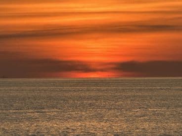 A stunning sunset over the ocean, creating a picturesque backdrop for any boating adventure. The tranquil waters reflect the vibrant colors of the sky, perfect for evening cruises.