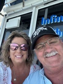 A cheerful couple takes a selfie aboard a boat, capturing a joyful moment on the water — perfect for memorable trips and adventures.