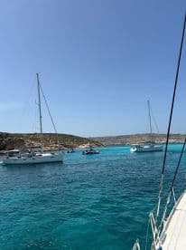 A picturesque view of multiple boats sailing in turquoise waters near an island, showcasing the beauty of a perfect day on the water.