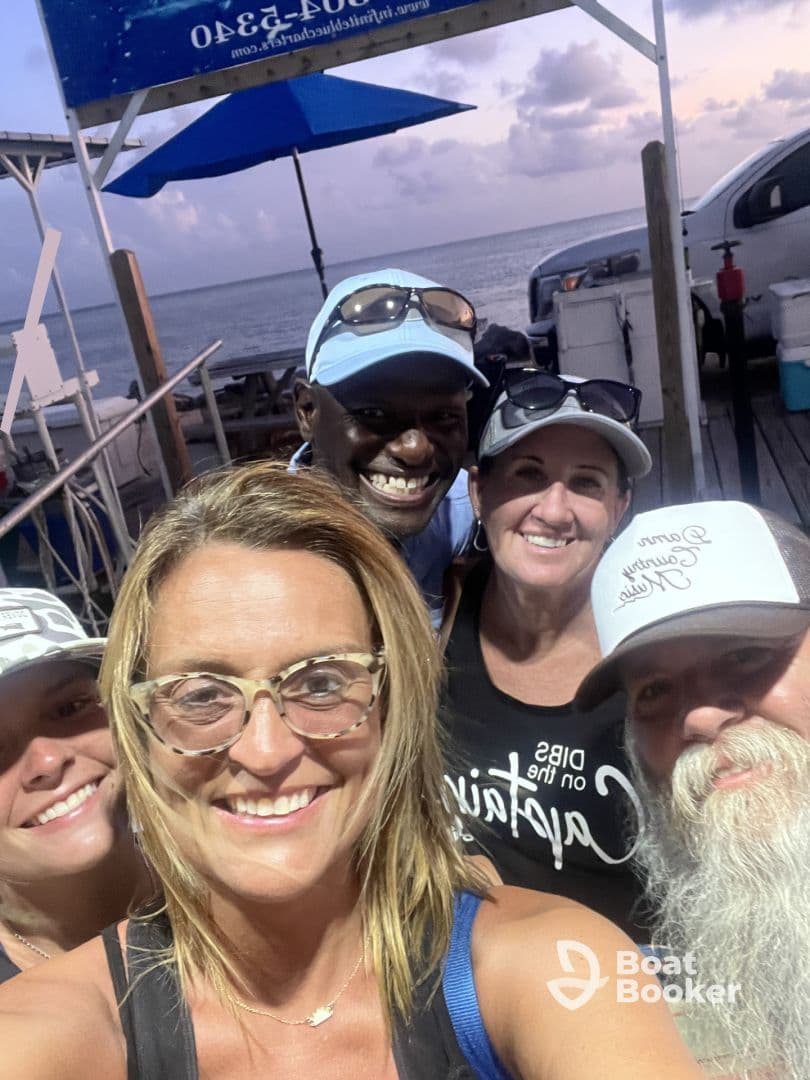 A cheerful group of friends poses for a selfie at a waterfront location, capturing the joy of their boating adventure together.