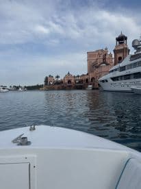A scenic view of a luxurious harbor featuring a stunning building and yachts, perfect for showcasing the beauty of waterfront destinations.