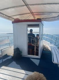 Inside view of the helm area on a boat, showcasing the captain's station and seating arrangements — perfect for navigating the open waters.