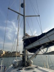 A detailed view of a sailboat's mast and rigging, showcasing the vessel's structure against a clear sky, ideal for sailing enthusiasts.