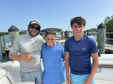 A group of three individuals poses on a boat, showcasing a fun day on the water. Perfect for capturing memories during a boating adventure.