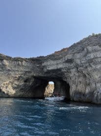 A scenic view of a boat navigating through a stunning cave along the coastline, showcasing the beauty of nature and adventure on the water.