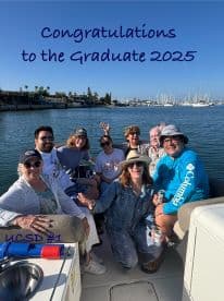 A joyful group celebrates a graduation aboard a boat, capturing the essence of family and friends enjoying a special occasion on the water.