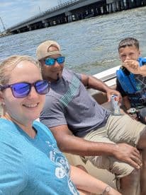 A joyful family enjoys a sunny day on the water, capturing memories while boating together. Perfect for family outings and summer adventures.