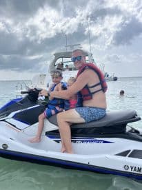 A joyful family enjoys a thrilling ride on a jet ski, creating unforgettable memories in the water. Perfect for summer adventures and family bonding.