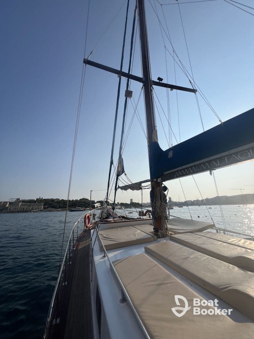 A stunning view of a yacht's side profile, showcasing its sleek design and rigging against a clear sky, perfect for sailing enthusiasts.