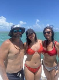 A cheerful group of friends poses together on a boat, enjoying a sunny day on the water — perfect for beach outings and summer celebrations.