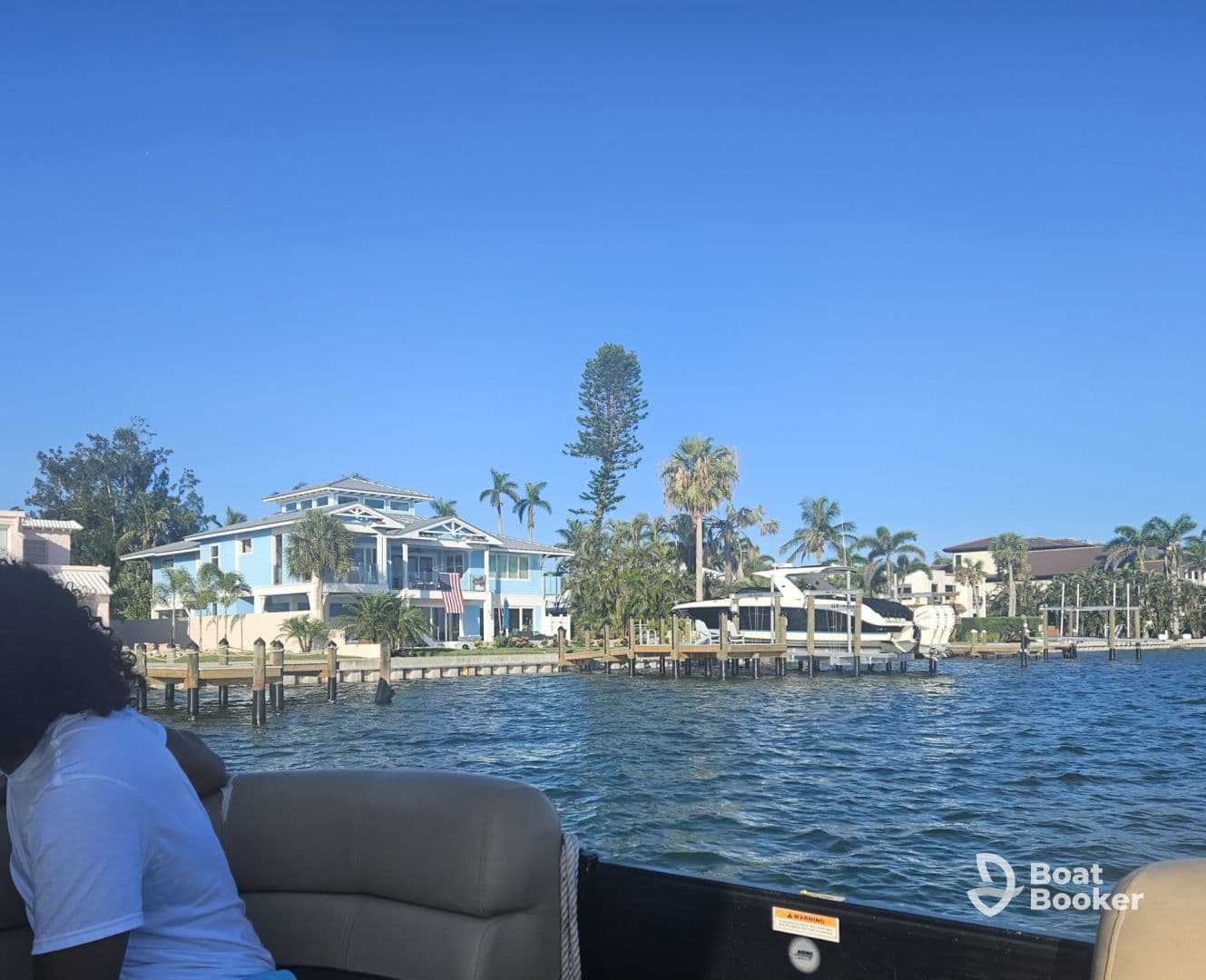 A scenic view of waterfront homes and a boat docked, with a guest enjoying the ride — perfect for capturing the essence of a relaxing day on the water.