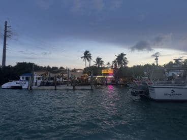 A scenic view of boats docked at a waterfront restaurant, showcasing the vibrant atmosphere of Robbies in the Florida Keys.