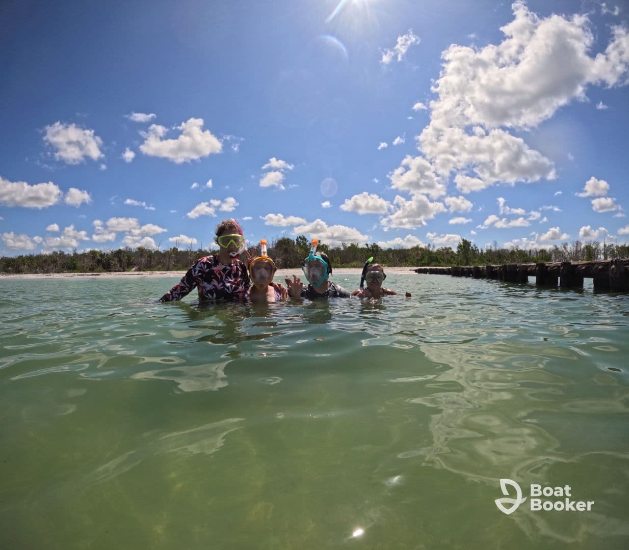 A joyful group of snorkelers enjoys a sunny day in the water, showcasing the fun of family adventures at the beach.