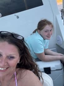 A joyful moment captured on a boat with a smiling woman and a young girl, showcasing the fun and bonding experiences that family outings on the water can offer.