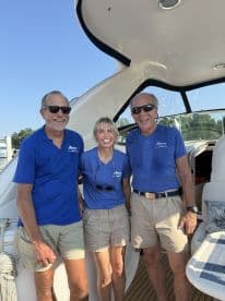 A cheerful group of boat crew members poses for a photo on board, showcasing the friendly atmosphere aboard the yacht — perfect for memorable sailing experiences.