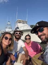 A cheerful group of friends enjoys a sunny day on the water, capturing a fun selfie aboard their boat — perfect for memorable outings and adventures.