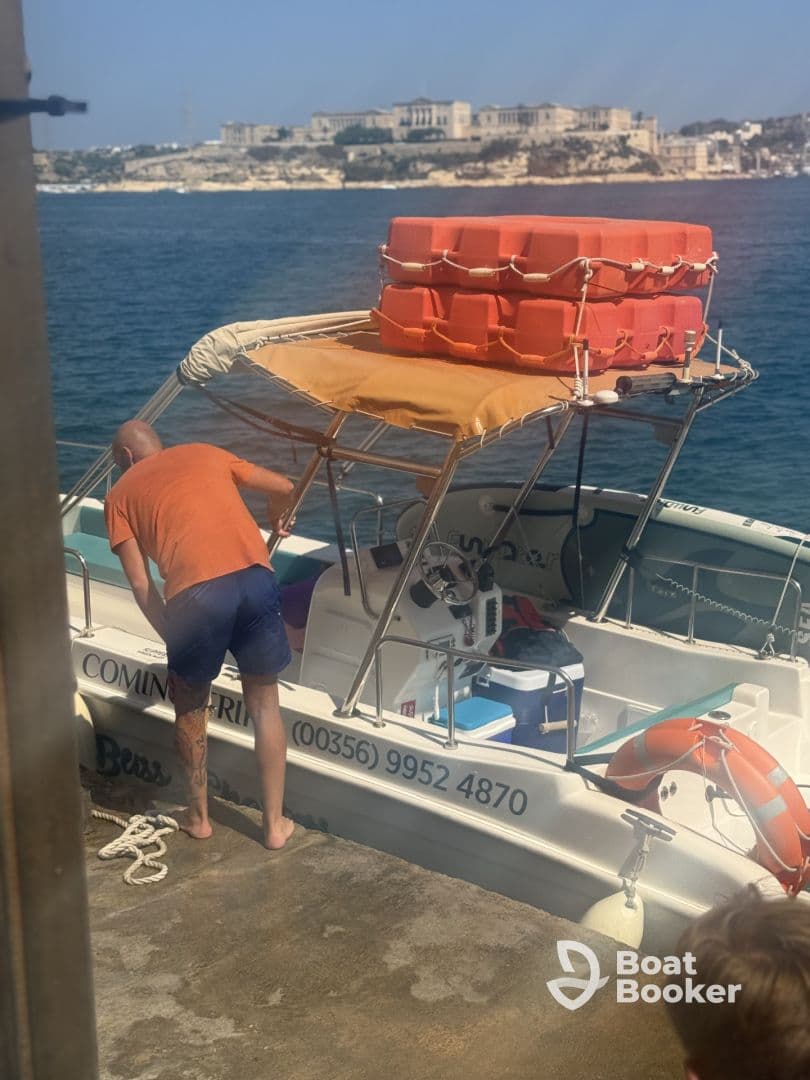A man prepares the helm of a boat, showcasing the interior setup and equipment, perfect for a day out on the water.